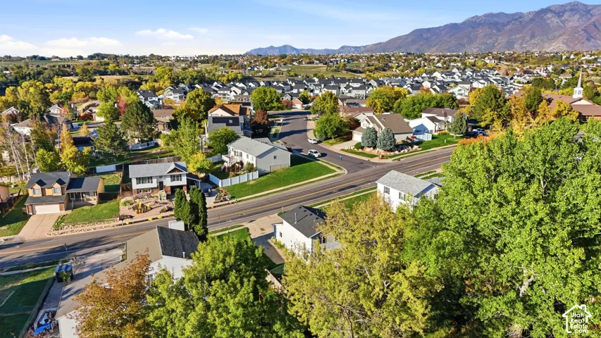Aerial perspective featuring mature trees, paved roadways, and prominent mountain backdrops