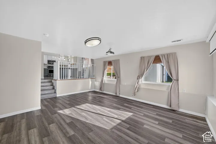 Wood-finish flooring, white railing balustrades, recessed ceiling lighting, and multi-pane windows