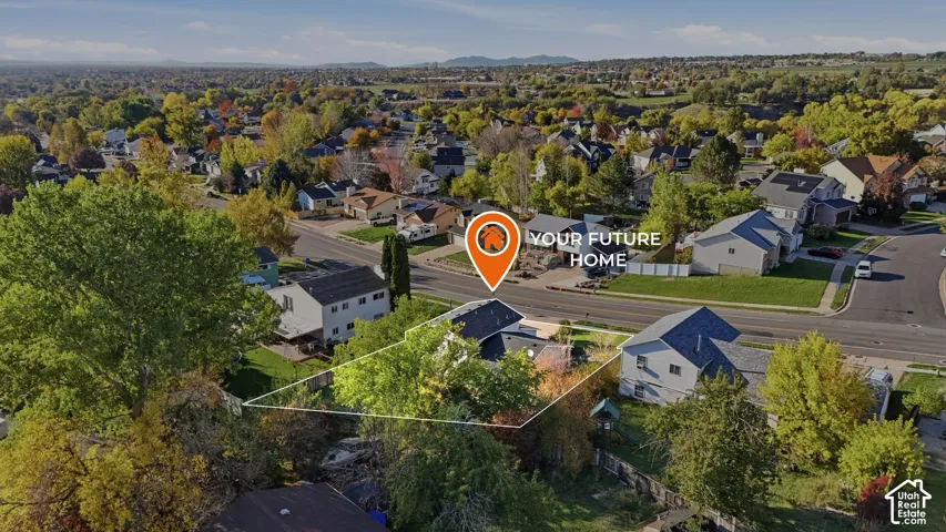 Aerial perspective featuring a residential lot with mature trees and a multi-level roofline