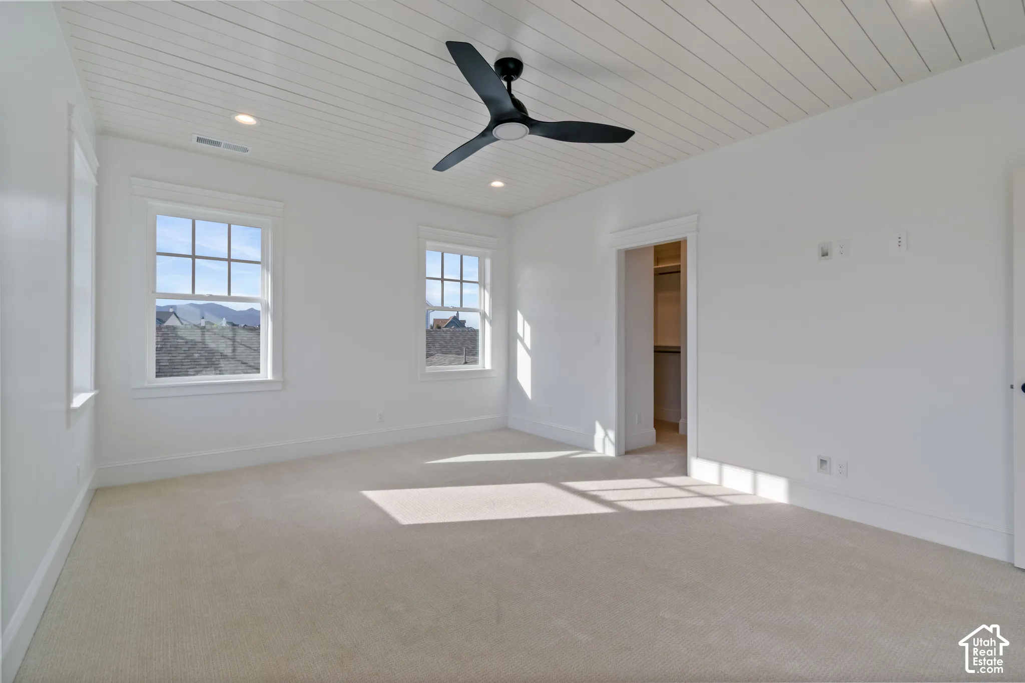 Plank-style ceiling, black three-blade ceiling fan, recessed lighting, carpeted flooring, and white window casing