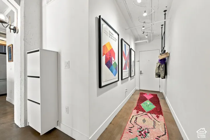 Wood-finish flooring, white walls, and a track lighting system