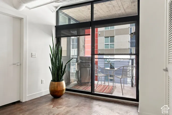 Polished concrete flooring, floor-to-ceiling glass doors, and exposed ceiling ductwork