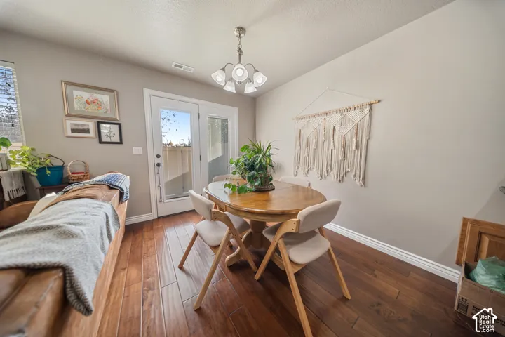 Wood-finish flooring, multi-light chandelier, and a glass-paneled exterior door