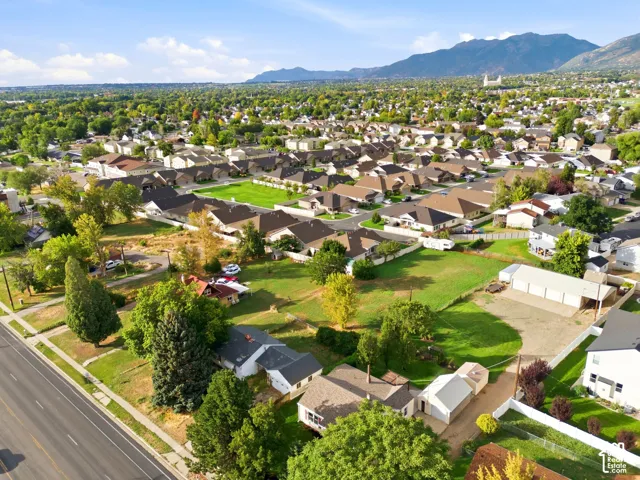 Aerial perspective featuring a detached garage, expansive lot, and mountain range backdrop