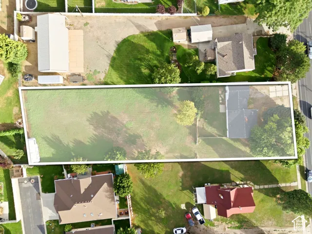 Aerial view of an expansive rectangular lot featuring mature trees and established lawn area