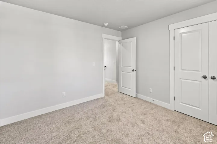 Neutral-toned carpeting, two-panel interior doors, and door casing with decorative header detailing