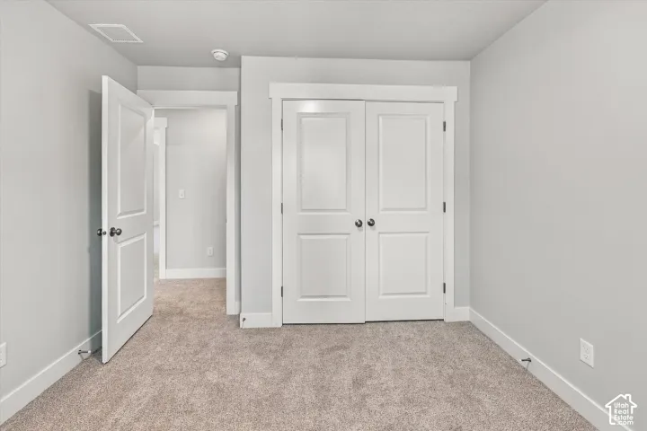 Neutral-toned wall paint, crisp white door trim, carpeted flooring, and double-panel doors featuring brushed nickel hardware