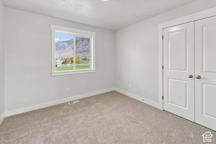 Neutral interior with wall-to-wall carpeting, window featuring mountain scenery, and double-panel doors
