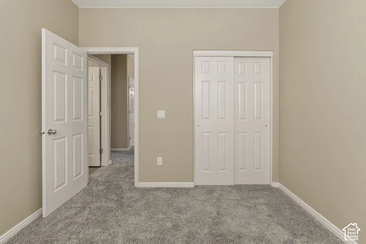 Neutral-toned interior featuring wall-to-wall carpeting, two-panel interior doors, and a sliding-door closet