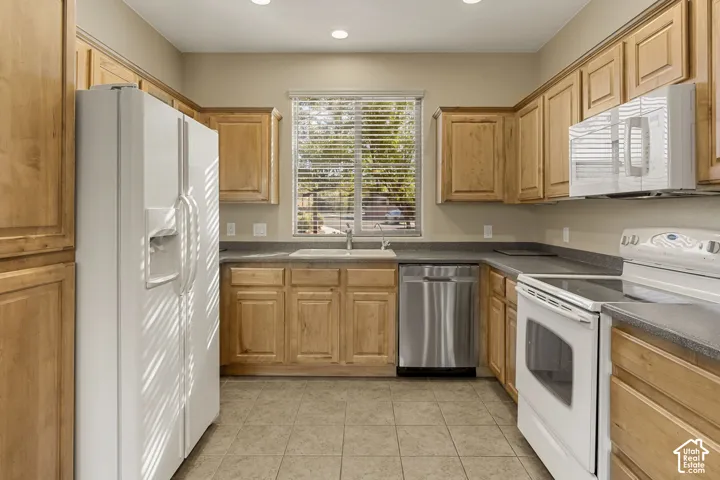Kitchen featuring shaker-style wood cabinetry, stone-composite countertops, stainless steel dishwasher, and recessed lighting