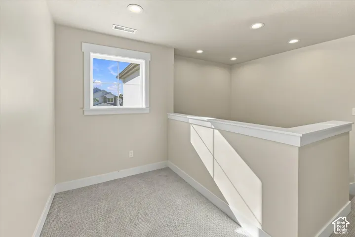 Neutral-toned interior space featuring recessed ceiling lighting, wall-to-wall carpeting, and a single-hung window with white casing and trim