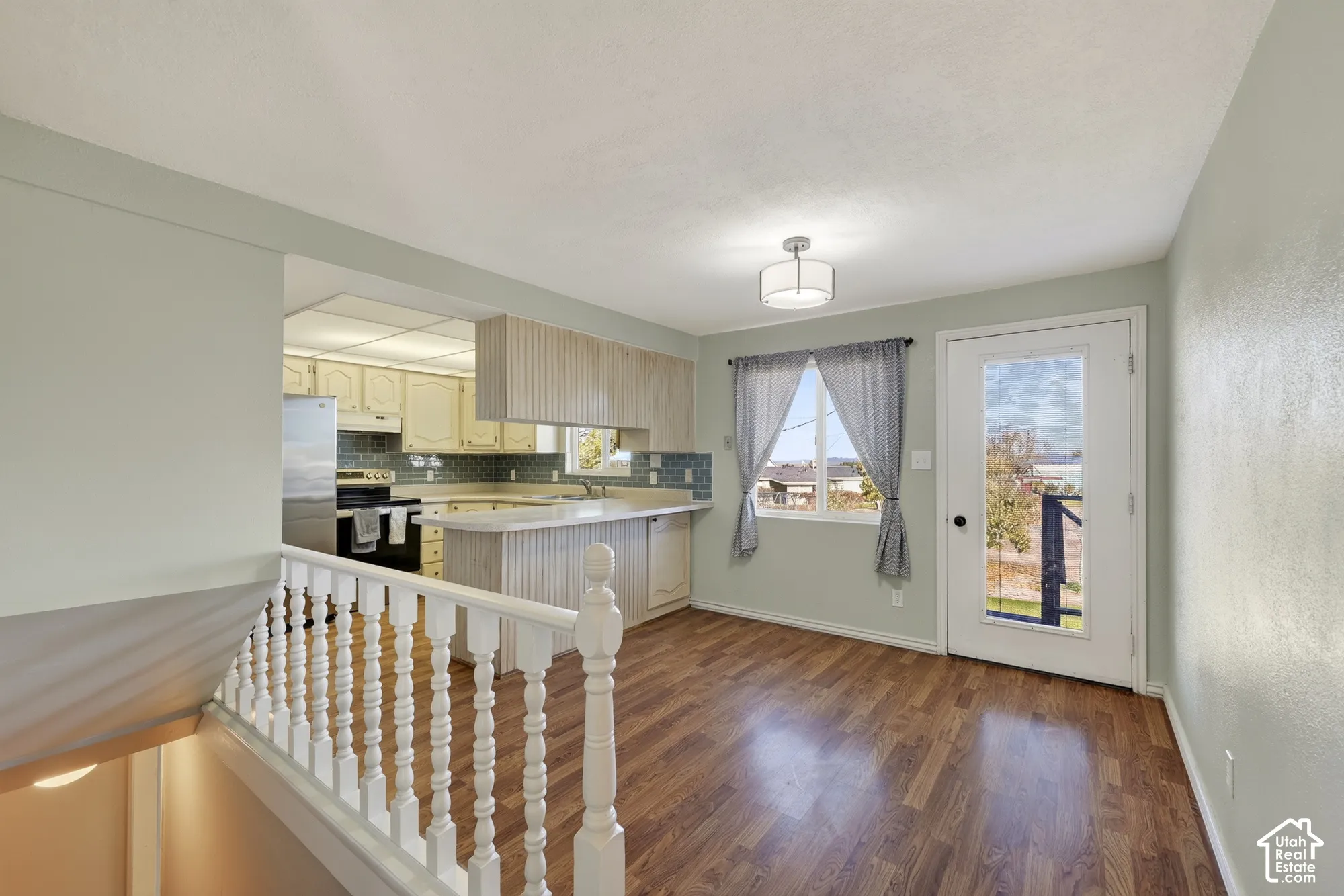 Kitchen featuring wood-finish cabinetry, wood-finish flooring, and a breakfast bar