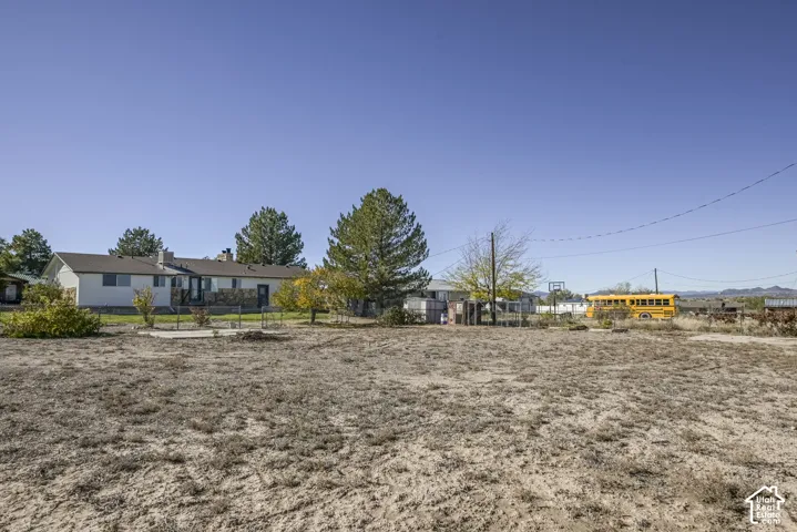 Expansive lot featuring stone exterior accents, mature trees, and mountain scenery