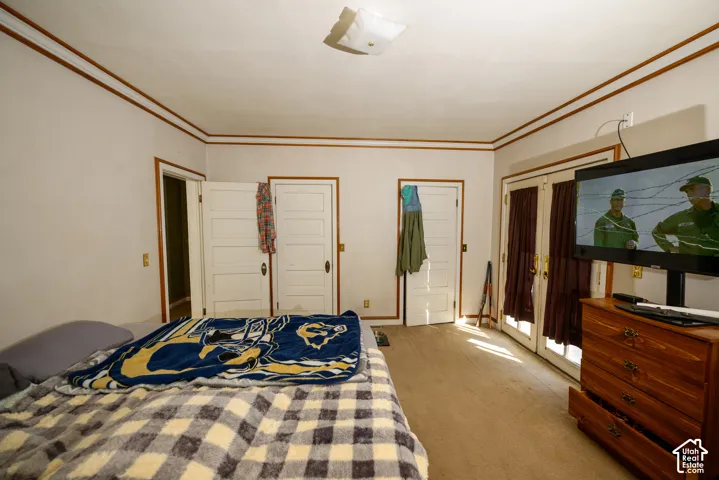 Room featuring multi-panel wood doors, crown molding, and glass-paneled double doors