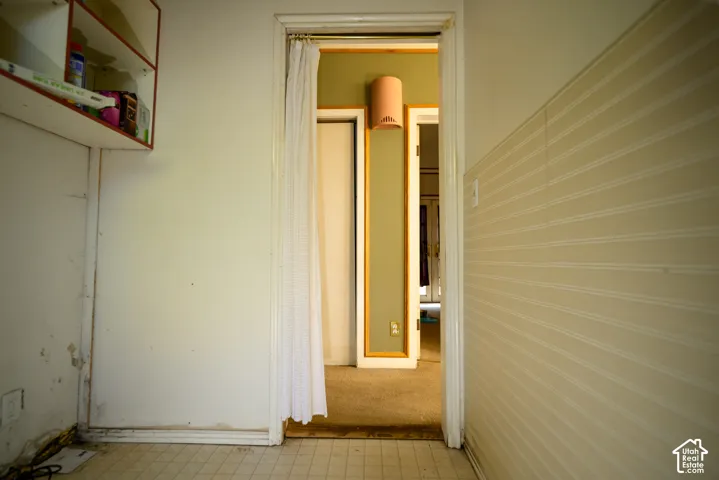 Built-in wall shelving with contrasting trim, vertical-groove wall paneling, and wall-mounted light fixture