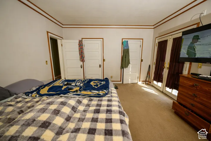 Interior room featuring five-panel solid-core doors, crown molding, and glass-paneled double doors