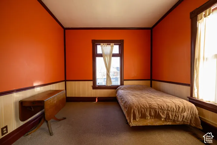 Interior room featuring dark wood-finish trim, vertical wainscoting, and multi-paned windows
