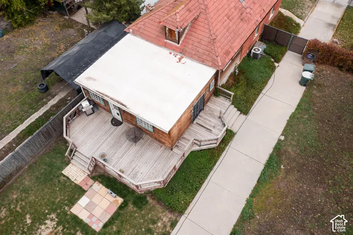 Multi-level exterior wood deck with integrated railings, tile patio hardscaping, and long concrete driveway