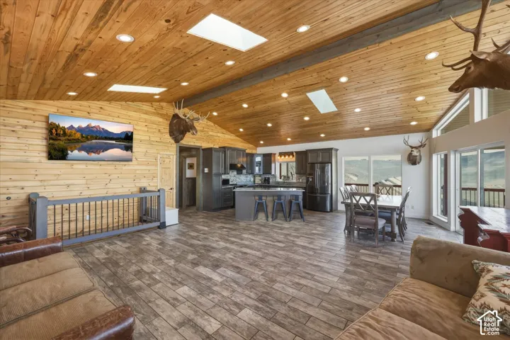 Vaulted ceiling featuring natural wood-finish planking and inset skylights