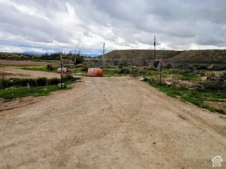Unimproved land parcel featuring gravel access path, open terrain, and mountainous topography