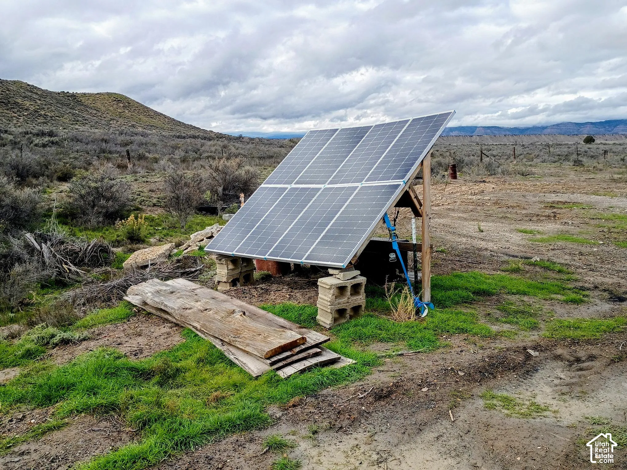 Ground-mounted solar array featuring a multi-panel configuration with a structural wood and metal frame supported by concrete masonry units