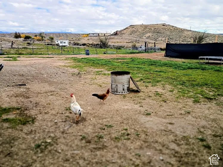 Expansive open acreage featuring wire perimeter fencing, natural desert landscape, and desert mountain backdrop