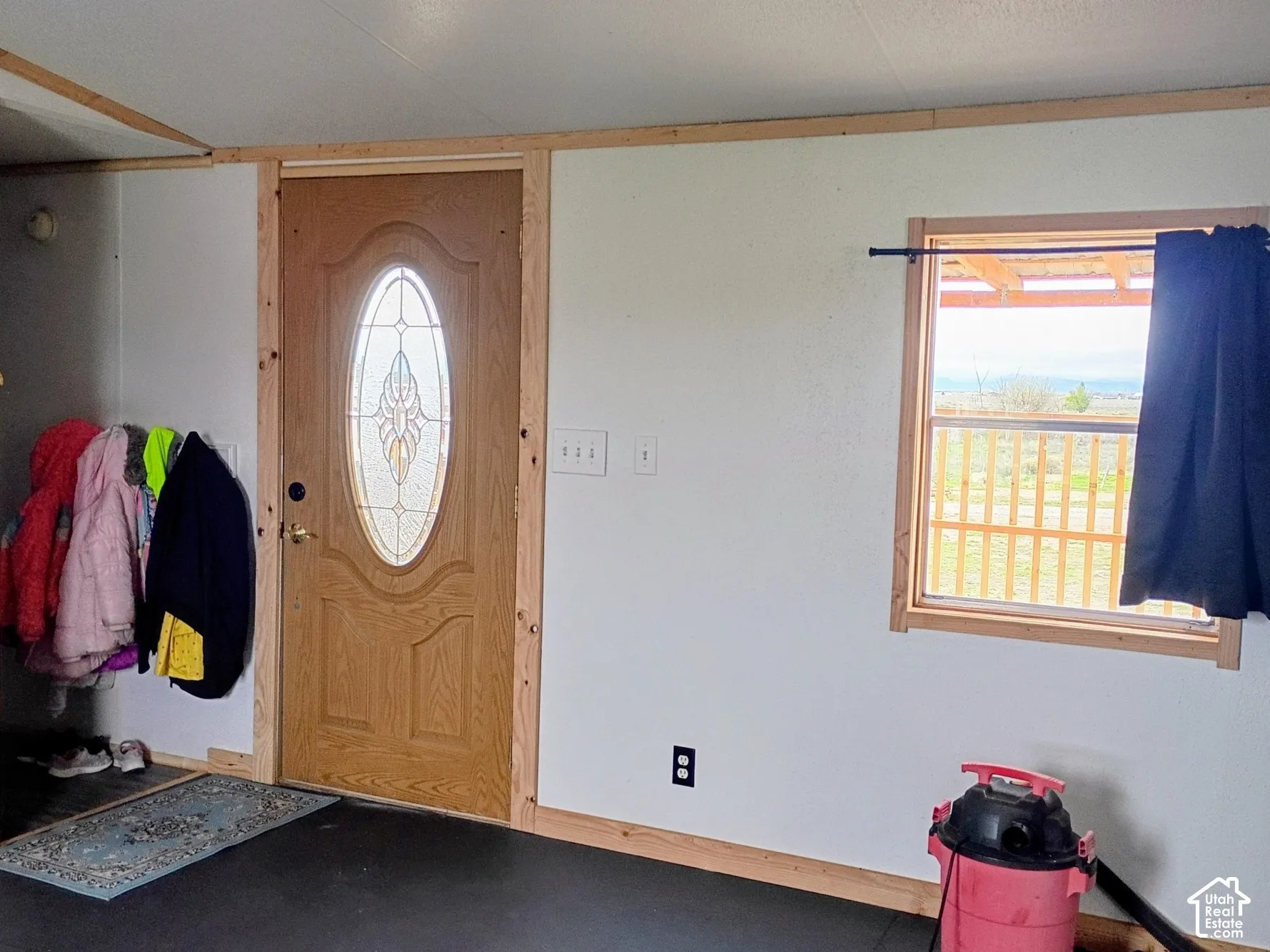 Exterior door with oval stained-glass inlay, natural wood window and door casing, and double-pane window