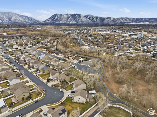 Aerial perspective featuring residential lots, paved cul-de-sac streets, surrounding open land, and a backdrop of mountain ranges