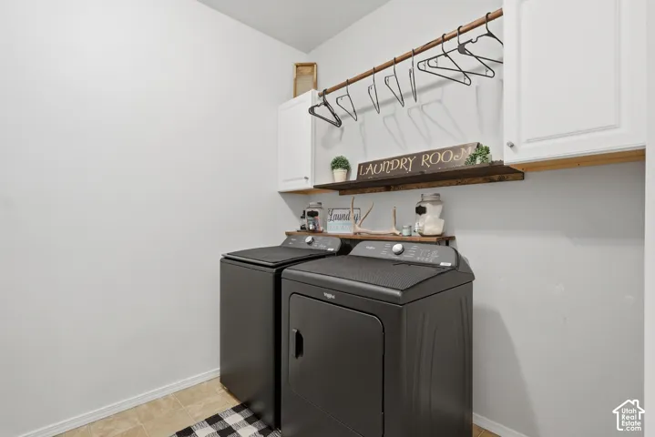 Laundry area featuring white cabinetry, a built-in wooden shelf, and a mounted metal hanging rod