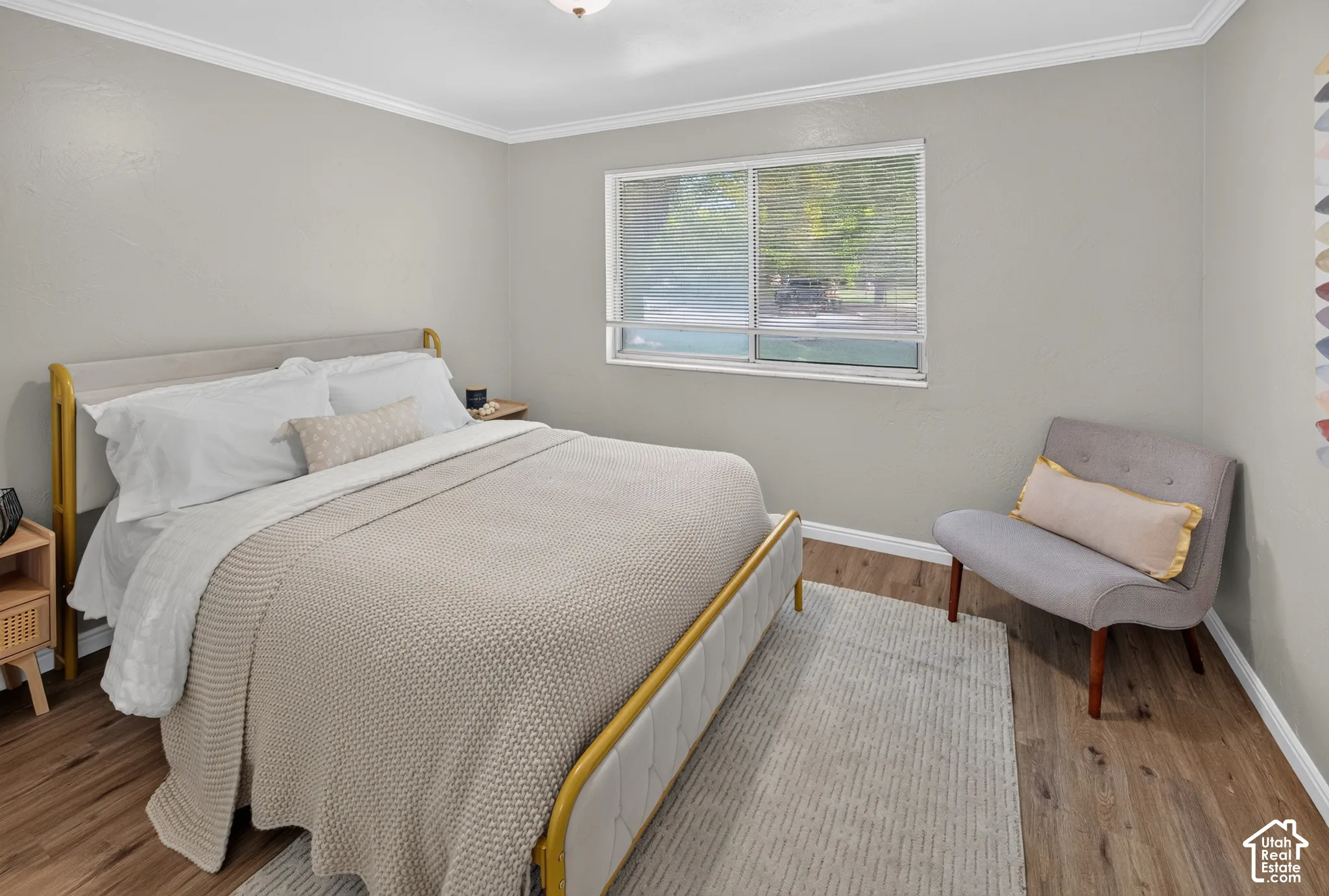 Neutral-toned interior walls with crown molding, wood-finish flooring, and a sliding window