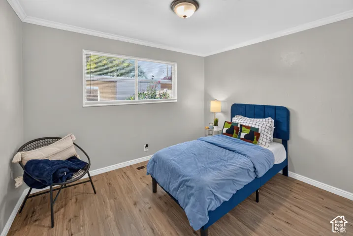 Neutral-toned interior room featuring wood-finish flooring, a horizontal sliding window, and a flush-mount ceiling light fixture