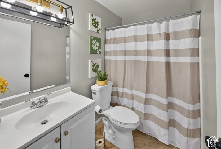 Bathroom featuring a white vanity with an integrated oval basin, polished chrome double-handle faucet, large wall-mounted mirror, and geometric gold-tone light fixture with four glass globes