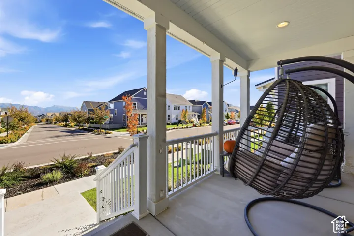 Covered front porch featuring a beadboard ceiling, recessed lighting, concrete flooring, and white railing with square balusters