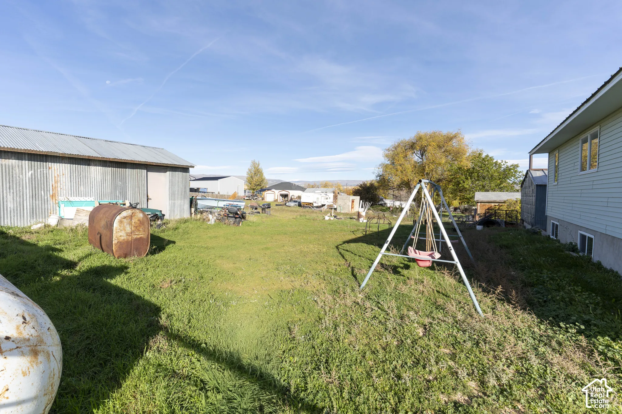 Expansive lot featuring a metal-sided outbuilding and open green space