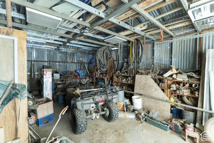 Outbuilding featuring corrugated metal walls, exposed structural metal framing, and a concrete floor