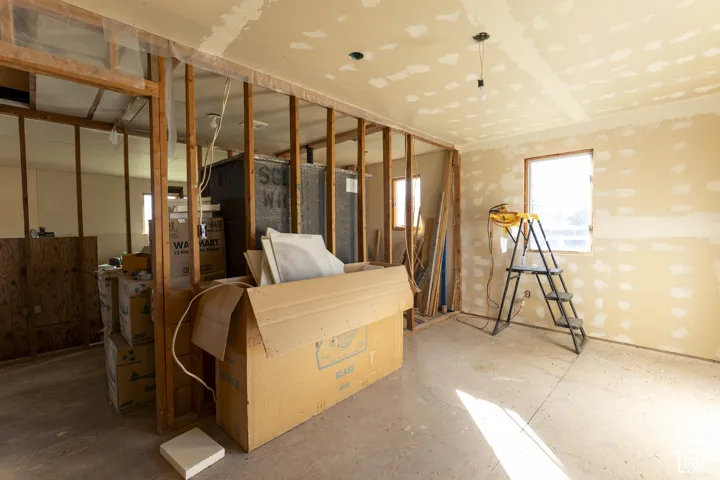 Interior space featuring exposed wood stud wall framing, partially finished drywall, and a single-pane window