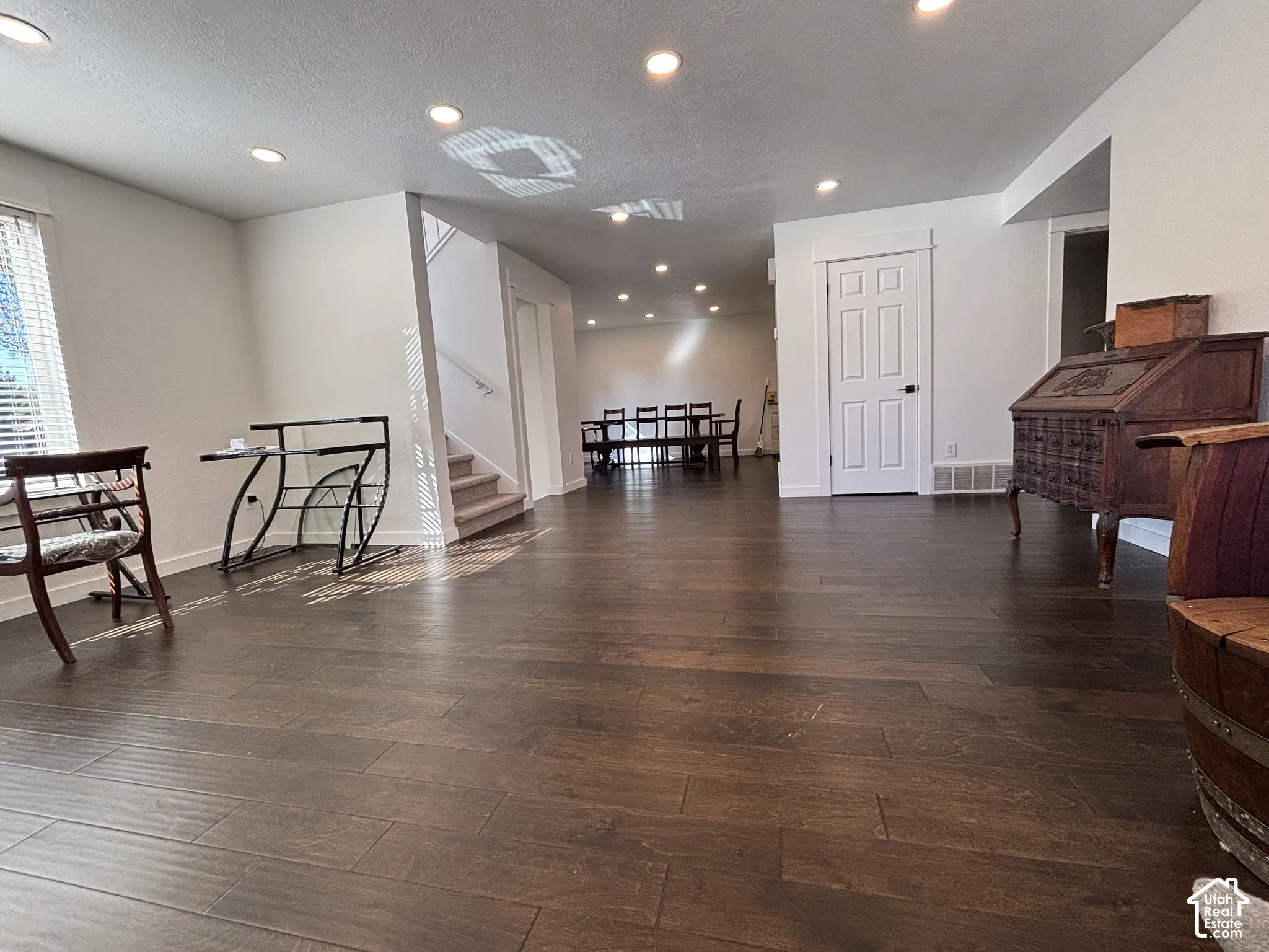 Interior space featuring wood-finish flooring, recessed lighting, and a six-panel interior door with white casing