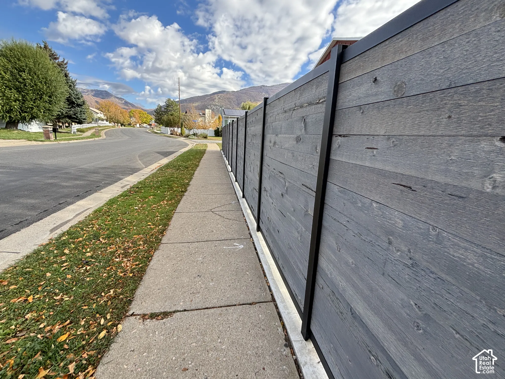 Horizontal wood-plank fencing featuring a dark-toned finish and black metal vertical supports