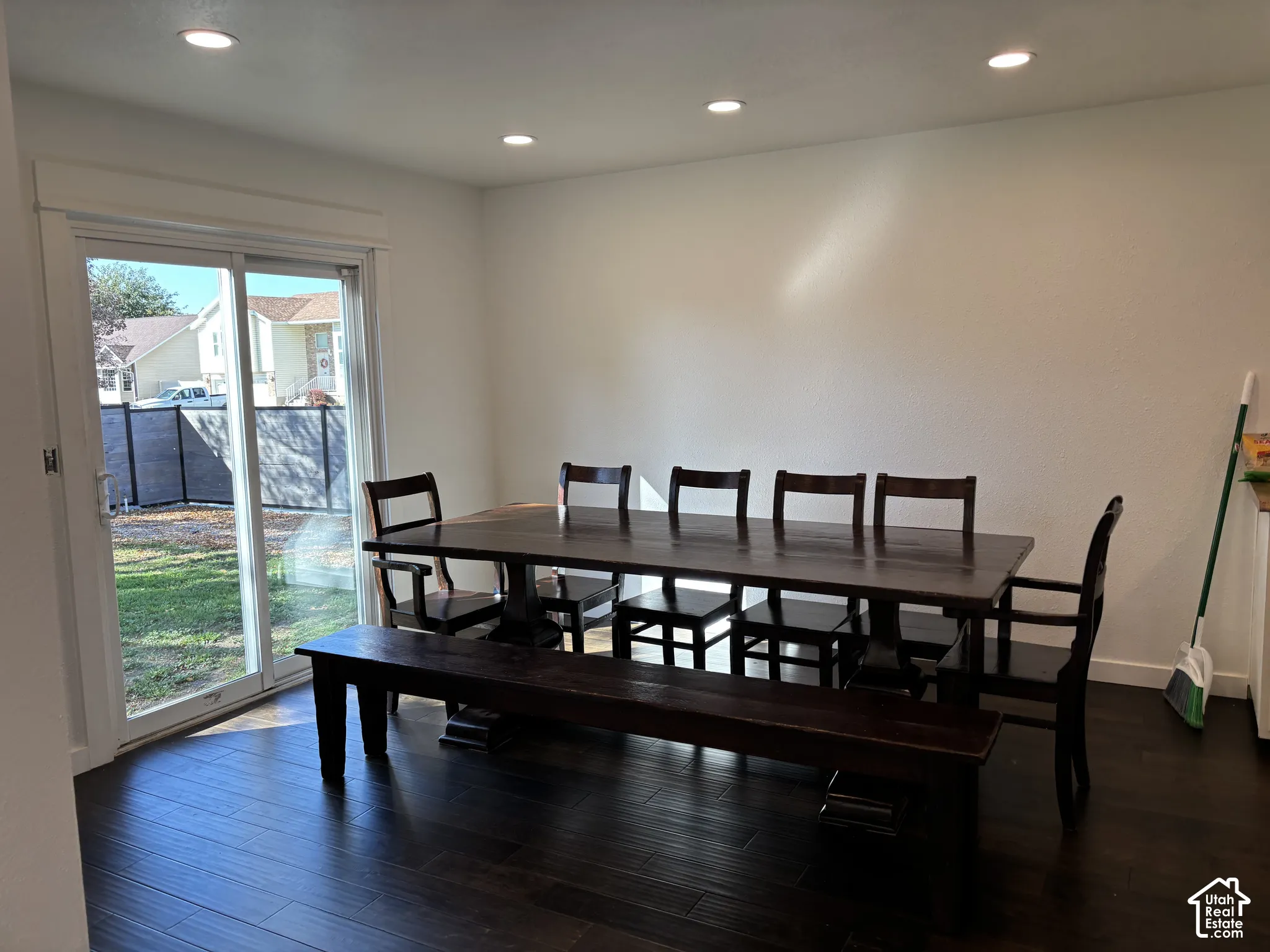 Dark-toned wood-finish flooring, recessed lighting, and a large sliding glass door