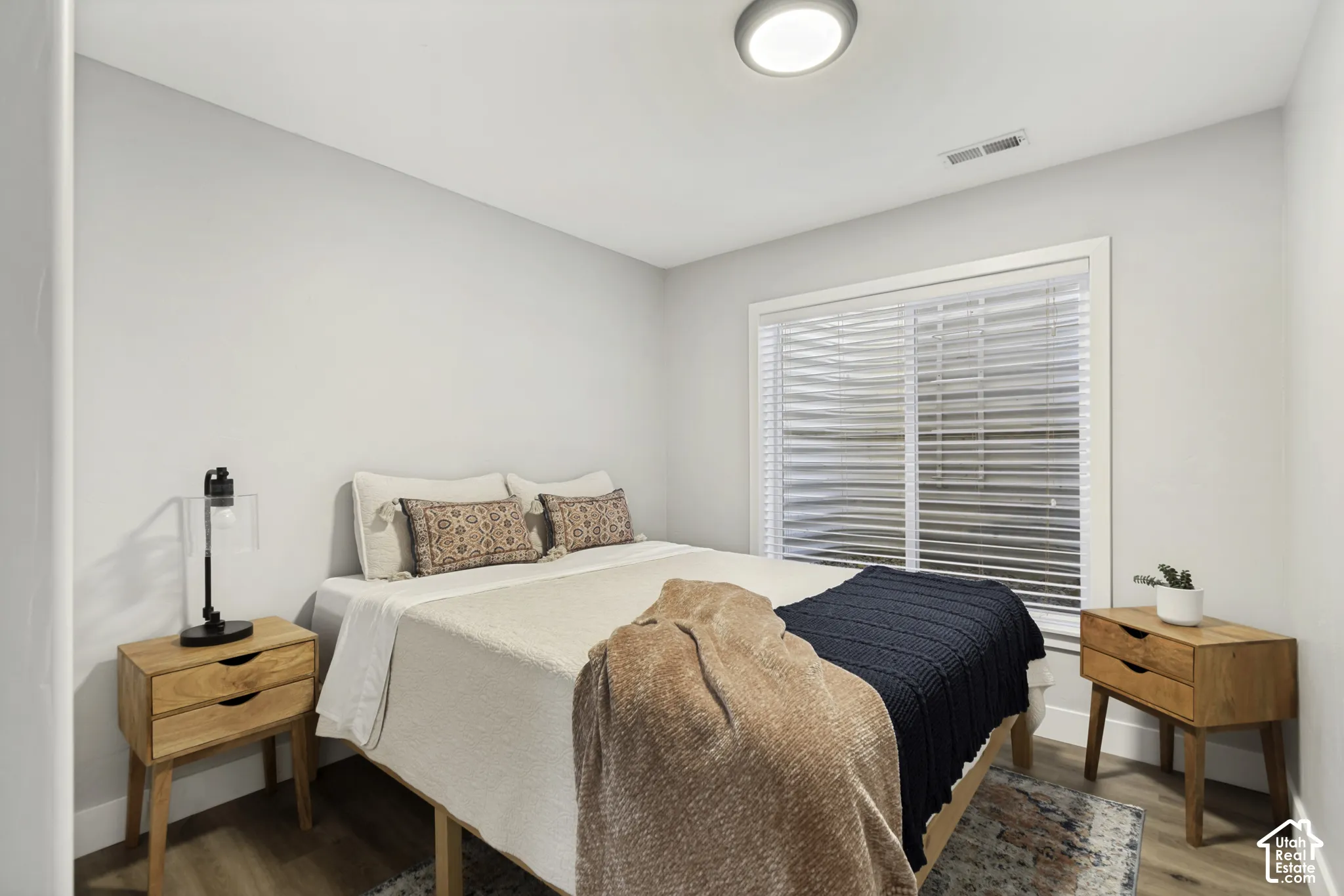 Neutral wall palette featuring wood-finish flooring, recessed ceiling lighting, and a window with horizontal blinds