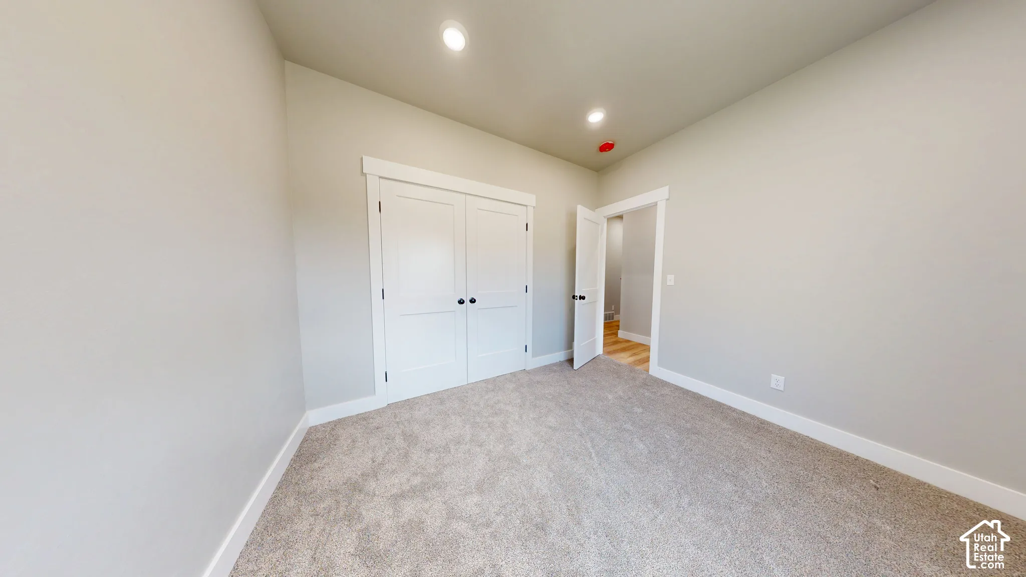 Neutral wall paint, high ceilings, recessed lighting, wall-to-wall carpeting, and double-door closet cabinetry