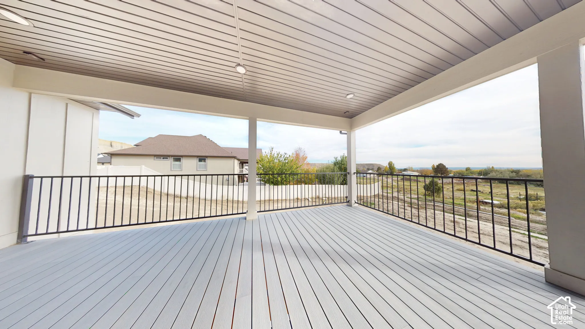 Covered patio featuring composite decking, recessed lighting, and metal perimeter railing