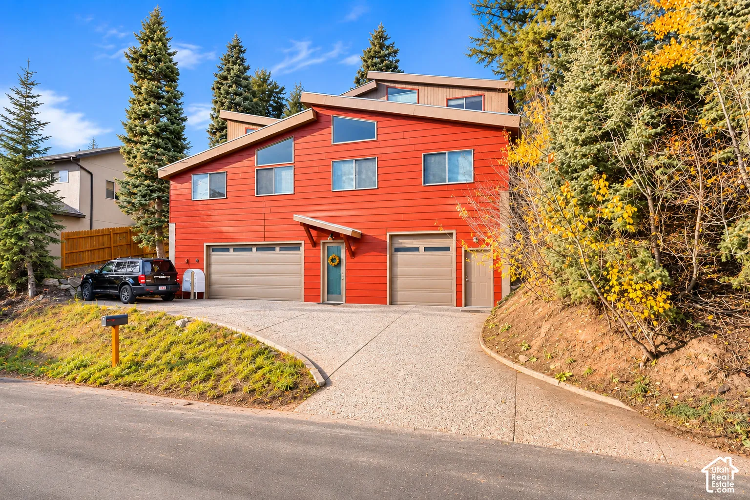 Multi-level exterior featuring horizontal siding, a concrete driveway, two attached garage bays, and multiple windows