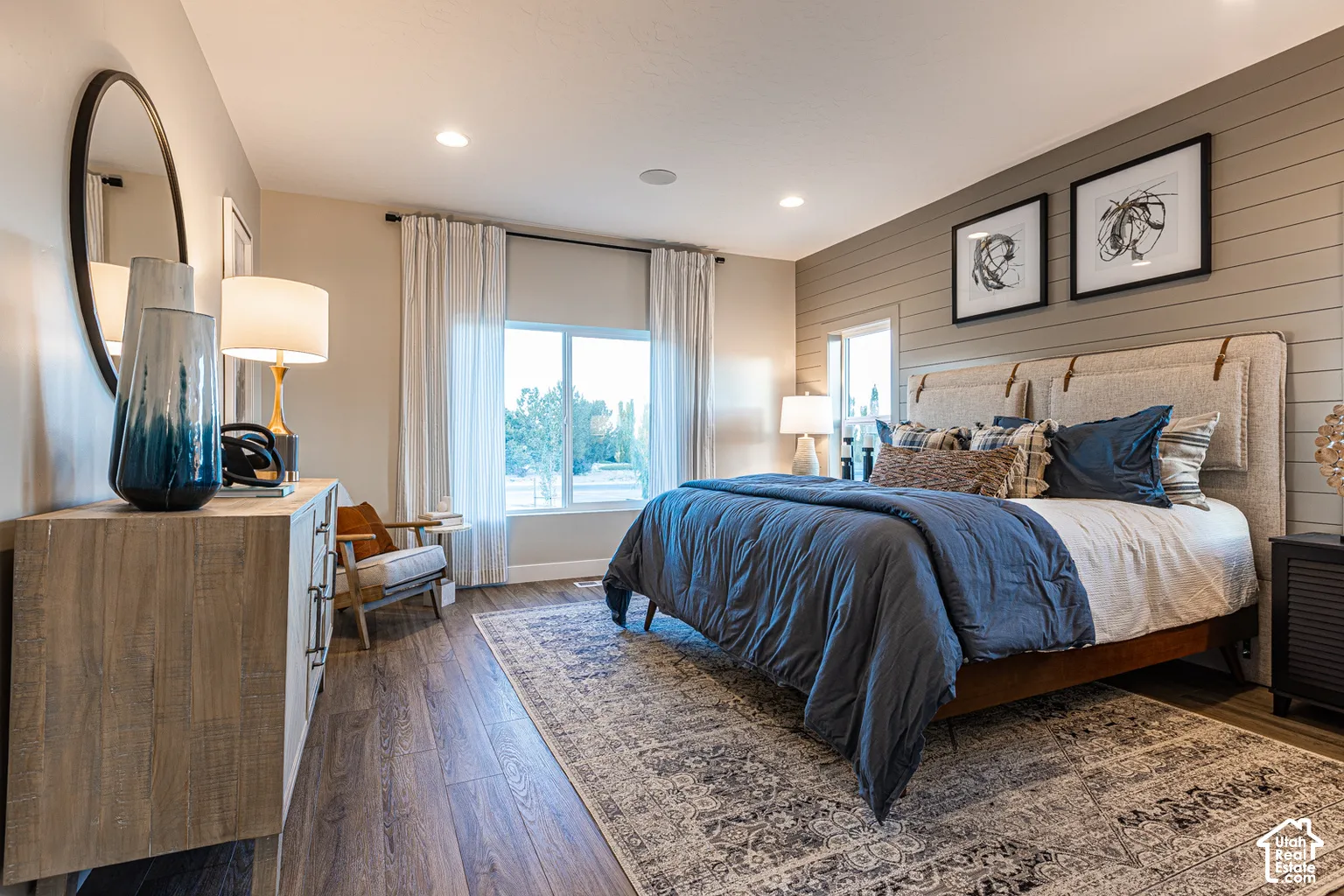 Room featuring wood-finish flooring, horizontal shiplap accent wall, recessed lighting, and large windows