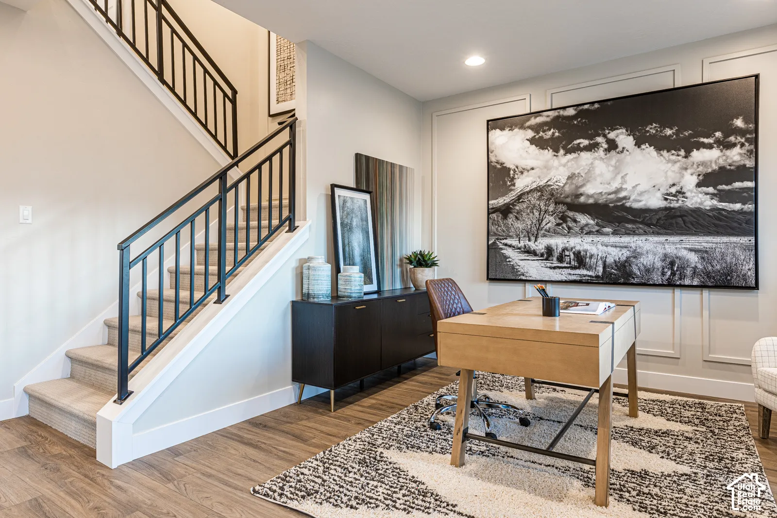 Staircase featuring a matte black metal railing and wall molding detail