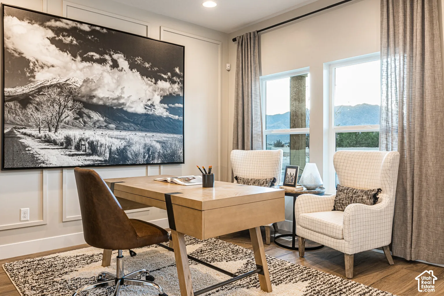 Wall molding detailing, wood-finish flooring, recessed lighting, and large windows with mountain scenery