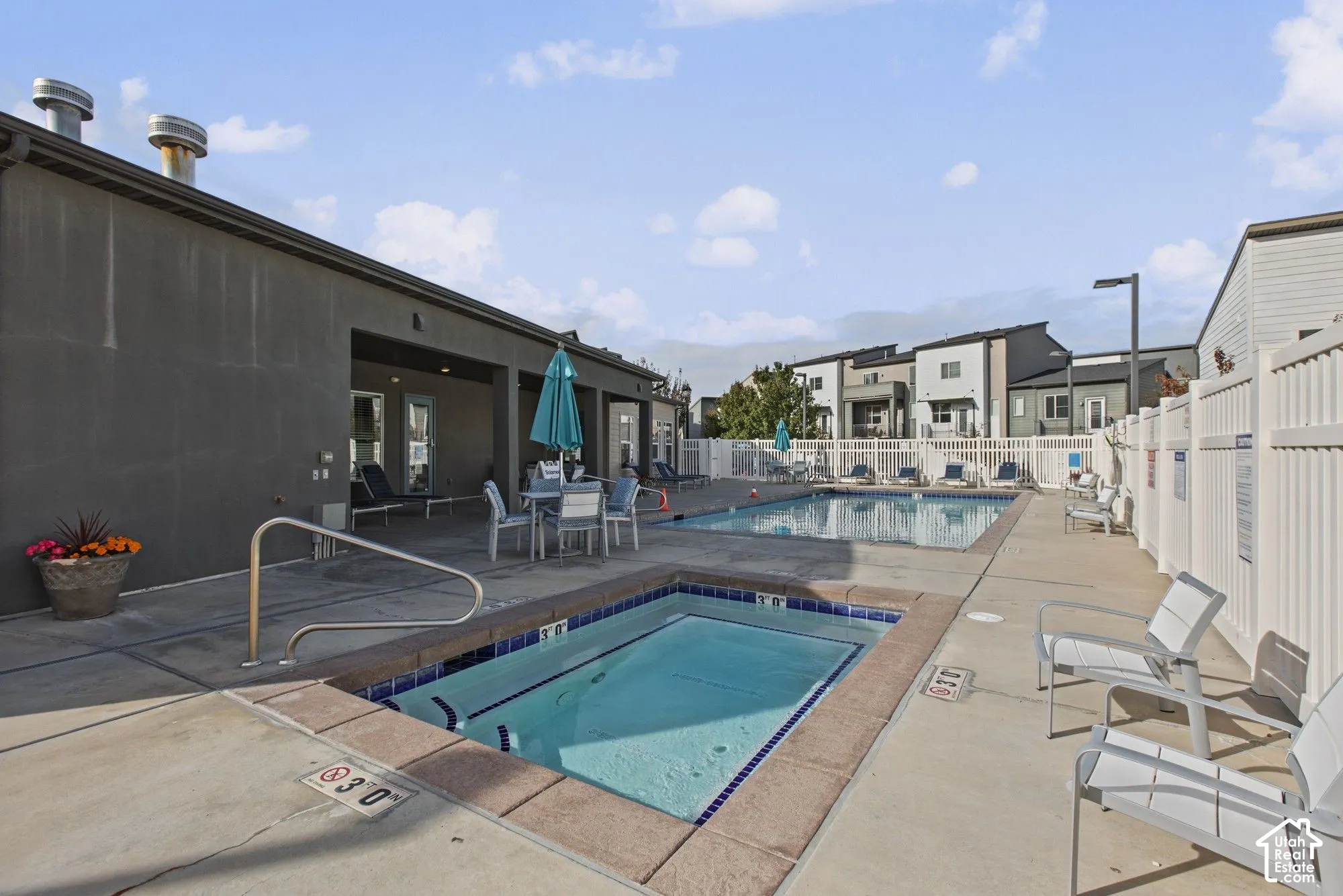 Outdoor recreation area featuring a swimming pool, integrated spa with tile perimeter, and expansive concrete decking