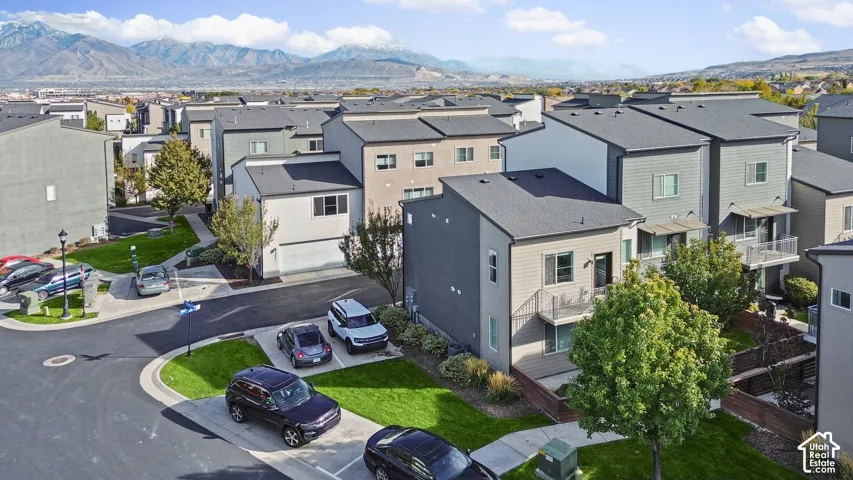 Multi-story residential exteriors featuring mixed-material siding, gabled rooflines, metal railed balconies, and mountain backdrops
