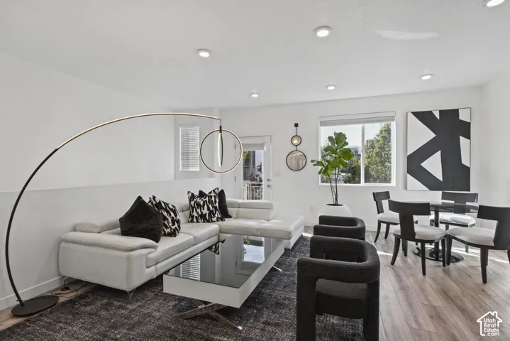 Open-concept interior featuring wood-finish flooring, recessed lighting, and crisp white walls