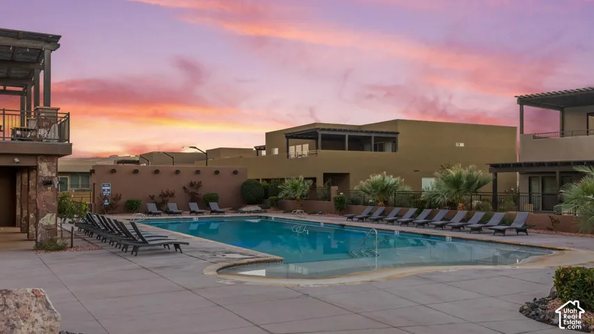 Outdoor swimming pool featuring a concrete deck, built-in pergolas, and stone accents